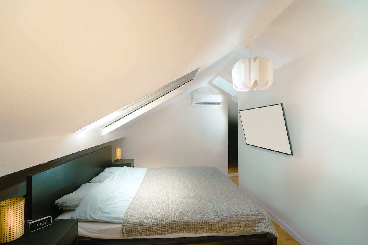 A sleek and minimalist attic bedroom with modern furnishings and natural lighting.